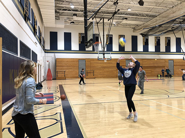 Freshmen Addie Seibel tosses a volleyball to her friend  freshmen Leah Freehling during channel 1. They are using their free time wisely. 