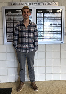 Senior Matt Cummings poses in front of the Knoch swim team record board where his name will be appearing soon. 