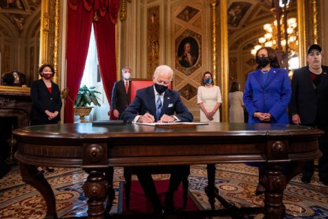 U.S. President Joe Biden signs three documents including an Inauguration declaration, cabinet nominations and sub-cabinet nominations, as U.S. Vice President Kamala Harris watches in the Presidents Room at the U.S. Capitol after the 59th Presidential Inauguration in Washington, U.S., January 20, 2021. Jim Lo Scalzo/Pool via REUTERS